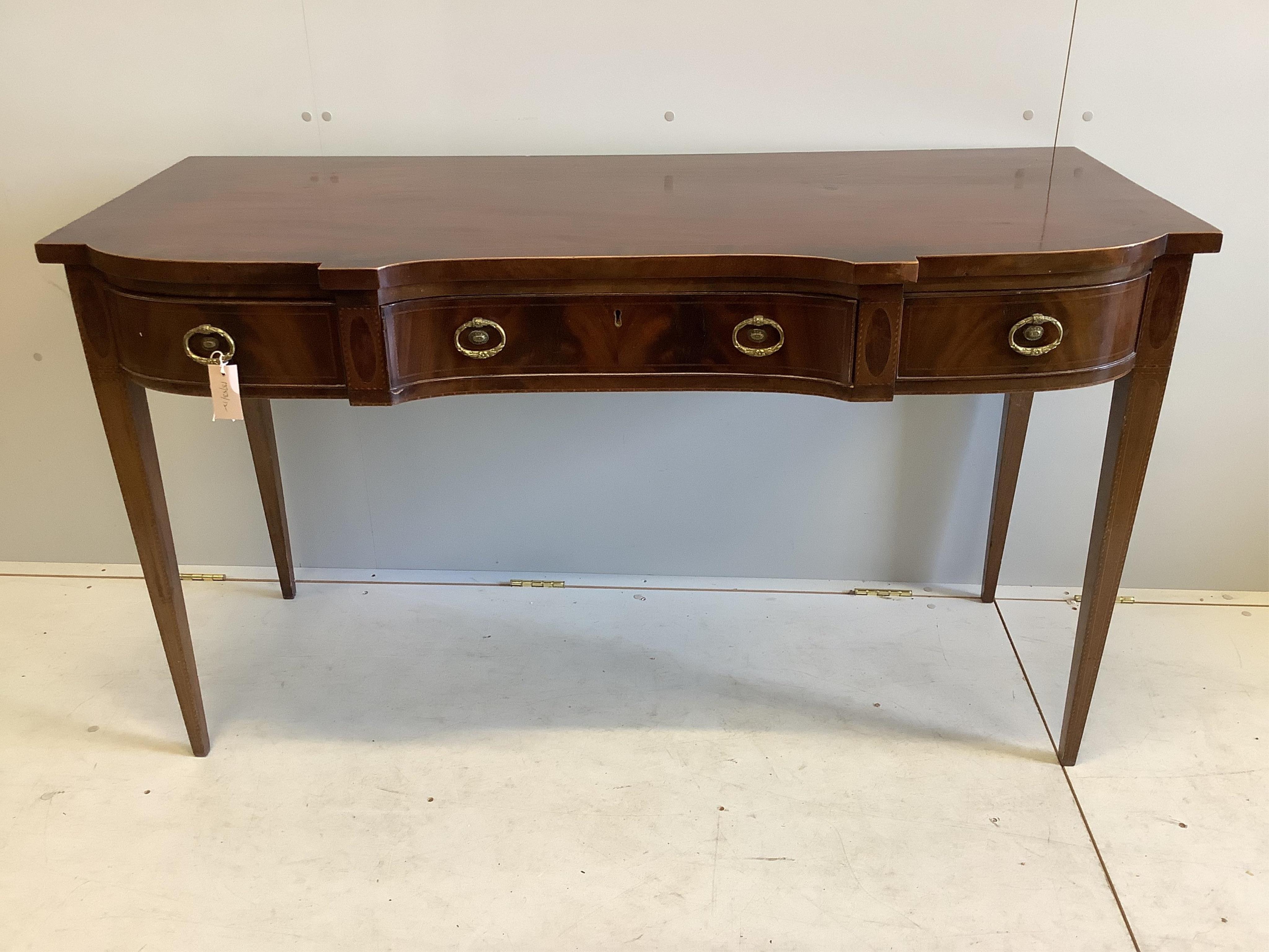 A late Georgian shape fronted mahogany serving table, fitted three frieze drawers with cast brass oval handles, raised on square tapering legs, width 145cm, depth 63cm, height 84cm